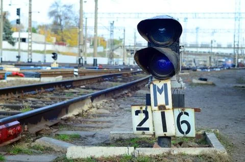 Semaphore with burning blue light. The intersection of railway tracks Stock Photos