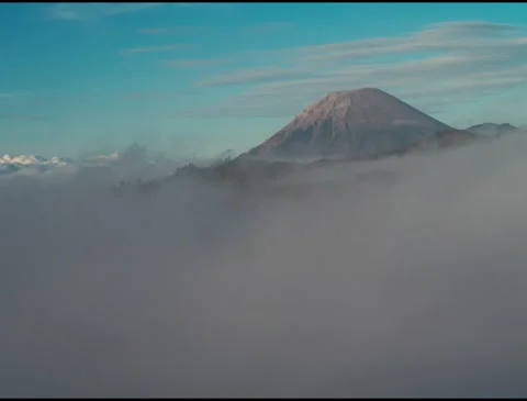 Semeru volcano rising above clouds in misty morning Java Indonesia - 4k Stock Footage 333485318