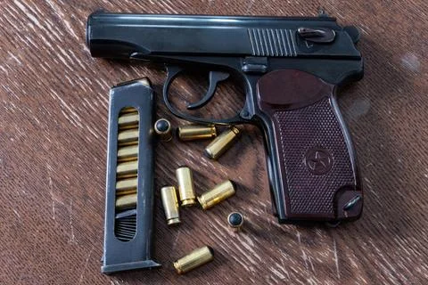 Semi automatic pistol next to detached magazine and rubber bullet cartridges Fotos Stock