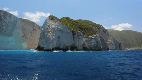 A semi circle view of green rock in the blue calm sea filmed from the boat. Stock Footage 199655112