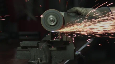 Semi close up of a worker with a grinding machine. A lot of sparks Stockbeeldmateriaal 74775502