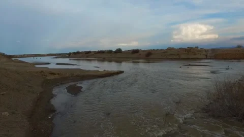 On a semi cloudy day a flooded river flows tranquilly, stock footage. Stock Footage 304784348
