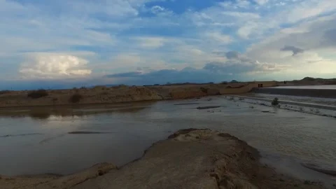 A semi cloudy sky hovers over a flooded river, stock footage. Stock Footage 304784357