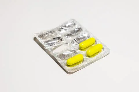 Semi-empty blister pack isolated on white background. Metal blister for cap.. Stock Photos