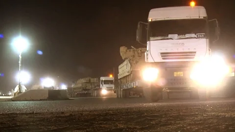 Semi-trailers transporting tanks move out in a convoy Stock Footage 113296363
