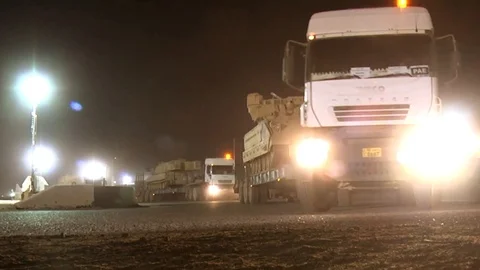 Semi-trailers transporting tanks move out in a convoy Stock Footage 113343162