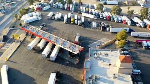 Semi-trailers trucks waiting in line to fuel at truck stop. Aerial hyper lapse  Stock Footage 202145493