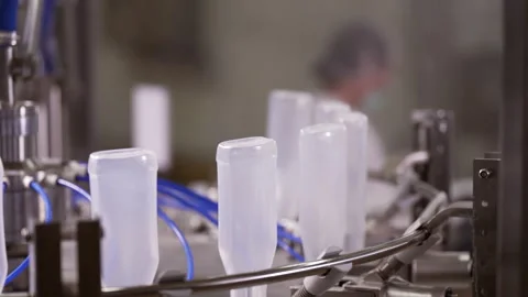 Semi-transparent plastic bottles moving through the production line. Video stock 250479864