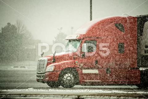 Semi truck hauler driving through blizzard snow conditions weather Stock Photos