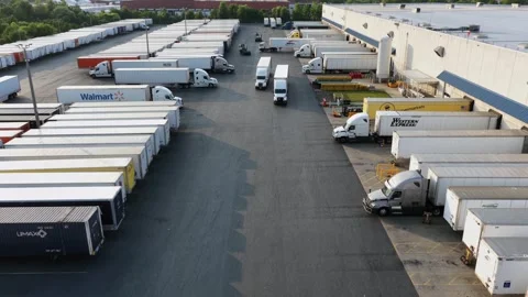 Semi trucks and trailers line loading docks at industrial distribution 库存影片 340968393