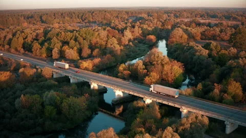 Semi-Trucks with cargo trailers drives along the road in the autumn forest. Stock Footage 166102381