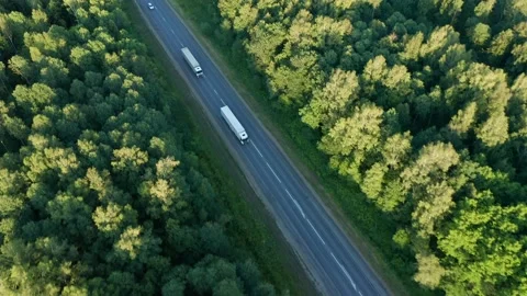 Semi-trucks with trailers move one after another. Long track, sunny day. The Stock Footage 157320306