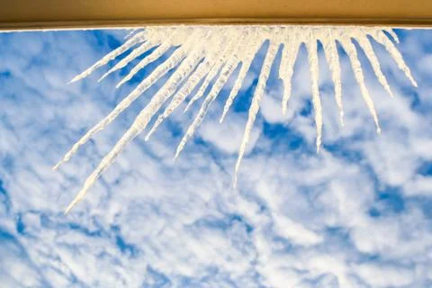 Semicircle of Large Sparkling Icicles on Window Frame at Sky Stock Photos
