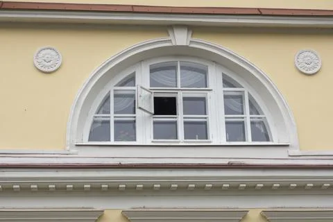 A semicircular window with an open window pane in the old manor museum. Stock Photos
