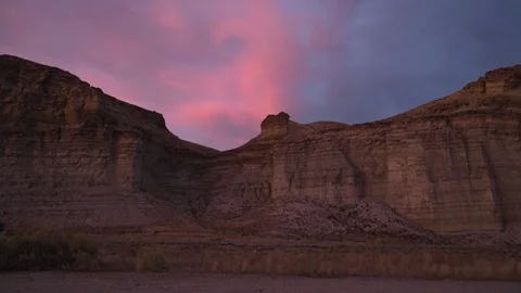 Semis passing in front of mountain gorge, sunset Stock Footage 86959397