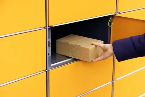 Send or receive parcel with self service post terminal machine. hand with pac Foto stock