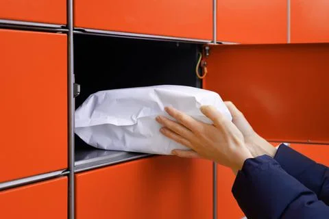 Send or receive parcel with self service post terminal machine. hand with pac Foto stock