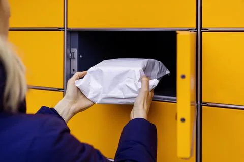 Send or receive parcel with self service post terminal machine. hand with pac Foto stock