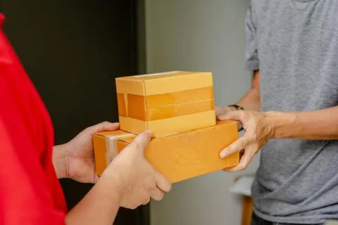 The sender in the red device sends the parcel box to the recipient at home, D Stock Photos