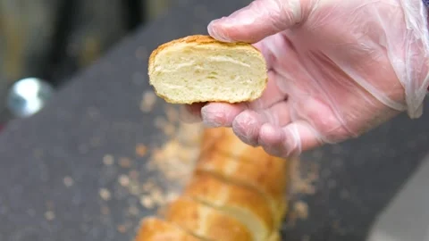 Sending bread to the cutting machine. Cutting a loaf of bread into pieces and Stock Footage 311098641