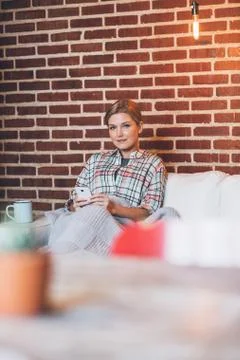 Sending a few texts from her sofa Stock Photos