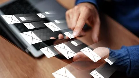 Sending messages through a device with a computer visible in the background 库存照片