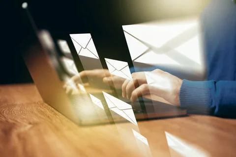 Sending messages using a laptop with email icons appearing on the screen Foto stock