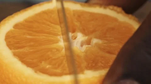 Senegalese Bartender Craft: Macro Close-up of African Hands Slicing Fresh Orange Stock Footage 309913845