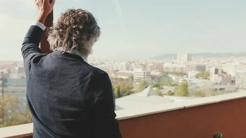 Senier enjoys the view standing on the balcony. Back view Stock Footage 229507449
