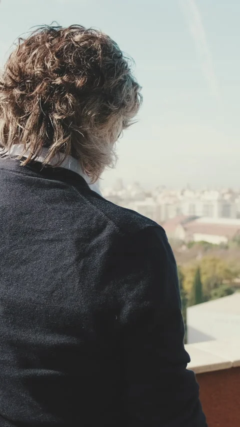 Senier enjoys the view standing on the balcony. Back view Stock Footage 229508104