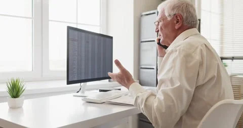Senior accountant on phone analyzing spreadsheets at desktop computer in office Stock Footage 338435369