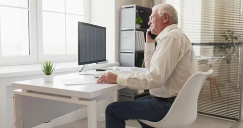 Senior accountant on phone analyzing spreadsheets at desktop computer in office Stock Footage 340551328