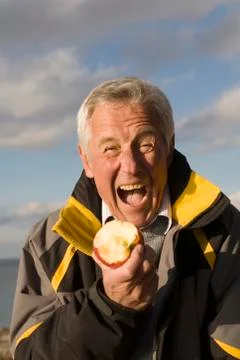 Senior adult man eating apple Stock Photos