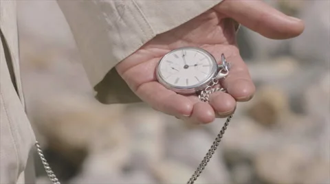 Senior adult's hand holding a silver pocket watch Stock Footage