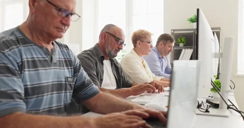 Senior adults learning computers in classroom, group training on desktop PCs Stock Footage 341459146