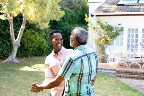 Senior African American couple dancing in their garden Stock Photos