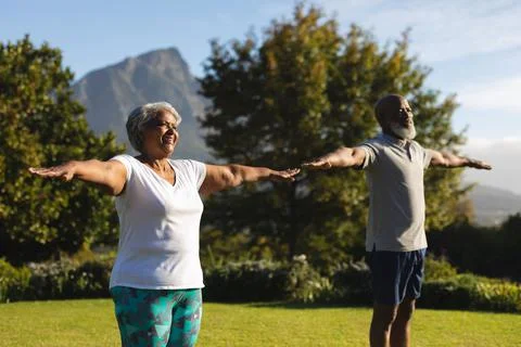 Senior african american couple practicing yoga in stunning countryside retreat Stock Photos