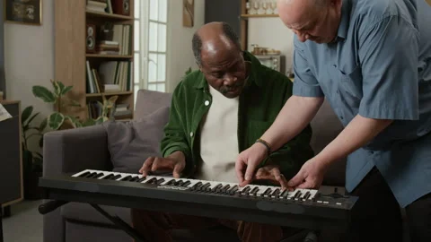 Senior African American Man Learning Piano at Home with Teacher Stock Footage 333418646