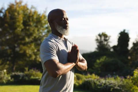 Senior african american man practicing yoga in stunning countryside Stock Photos