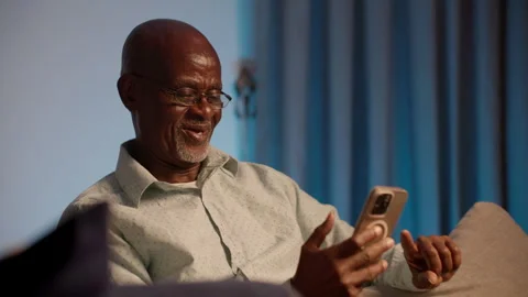 Senior African Citizen Using Smartphone for Family Video Call Video stock 346007804