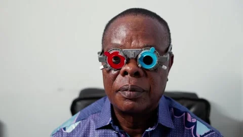 Senior African man undergoing eye test with a trial frame for vision correction Stock Footage 346770293
