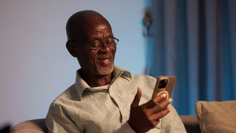 Senior African Man Using Smartphone for Video Call with Family Overseas Stock Footage 346007339