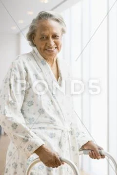 Senior African woman in bathrobe using walker Stock Photos