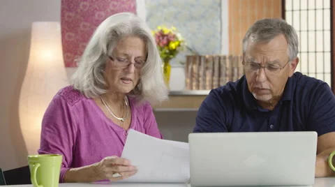 Senior aged couple looking at their bills Stock Footage