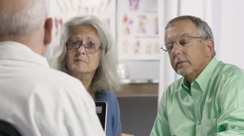 Senior aged couple talking to Doctor Stock Footage