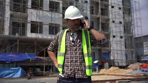 Senior architect or civil engineer talking to phone pointing finger to insp.. Stock Footage 262154172