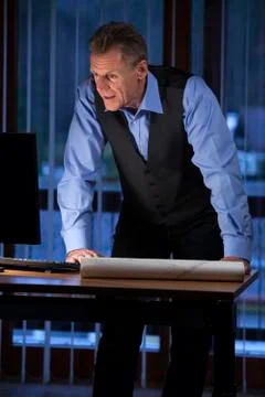 Senior architect or engineer standing at his desk looking at computer screen 스톡 사진