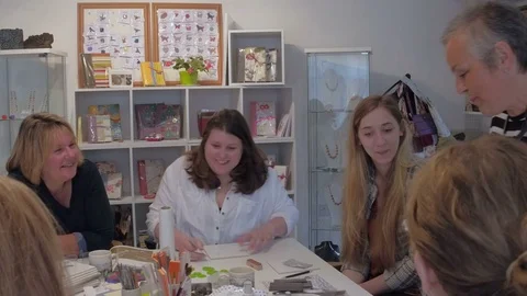Senior artist in studio teaching students about silver clay Stock Footage 76852558