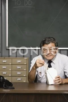 Senior Asian businessman eating takeout food Stock Photos