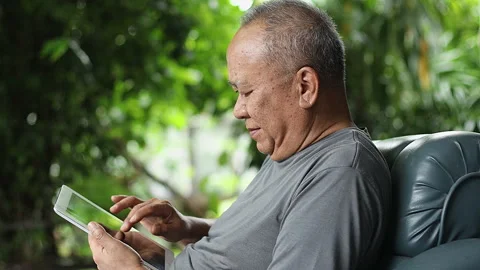 A senior Asian man is using social media on his laptop. Stock Footage 250320371